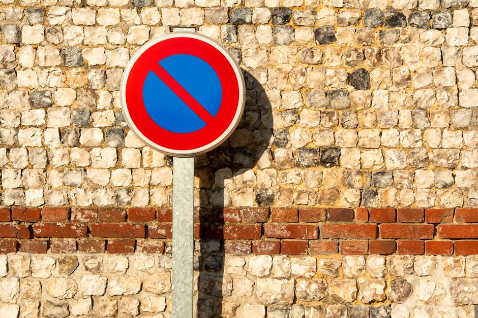 A close-up photograph of a white and black street sign mounted on a black pole, indicating 'Redchurch Street' in the London Borough of Hackney, with the postcode E2. The sign is positioned at a street